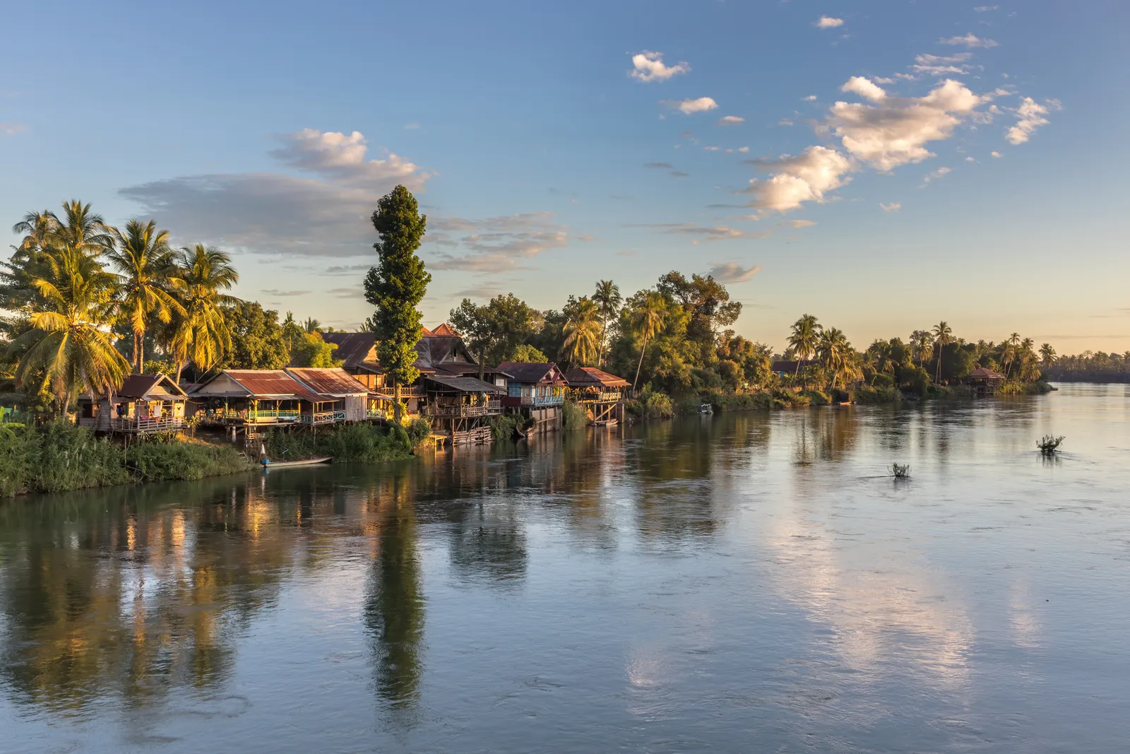 Case su palafitte sulla sponda del Mekong a Don Det, Si Phan Don, Laos, all'ora dorata