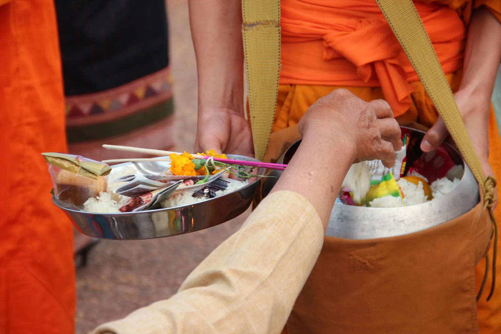 Le offerte ai monaci durante il festival Offerte di riso e fiori ai monaci buddisti durante il Festival di Wat Phou a Champasak, nel sud del Laos