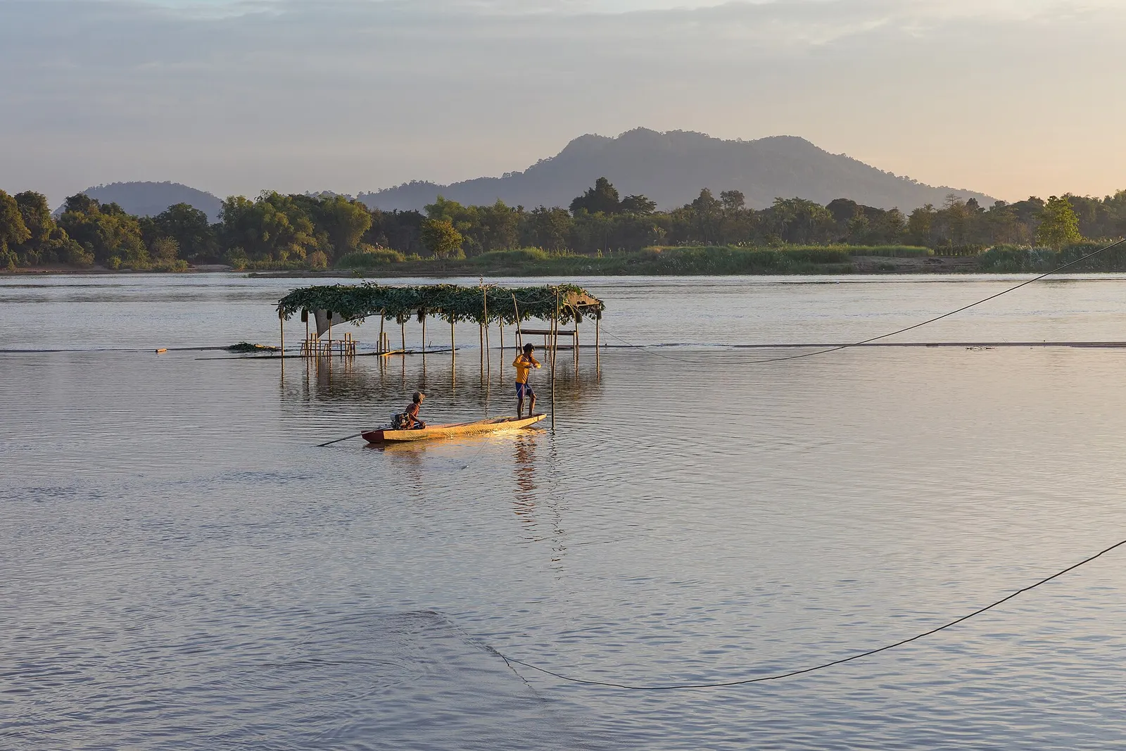 Tramonto sul fiume Mekong alle 4000 isole di Si Phan Don, piroga solitaria e cielo rosa per chiudere la luna di miele in Laos