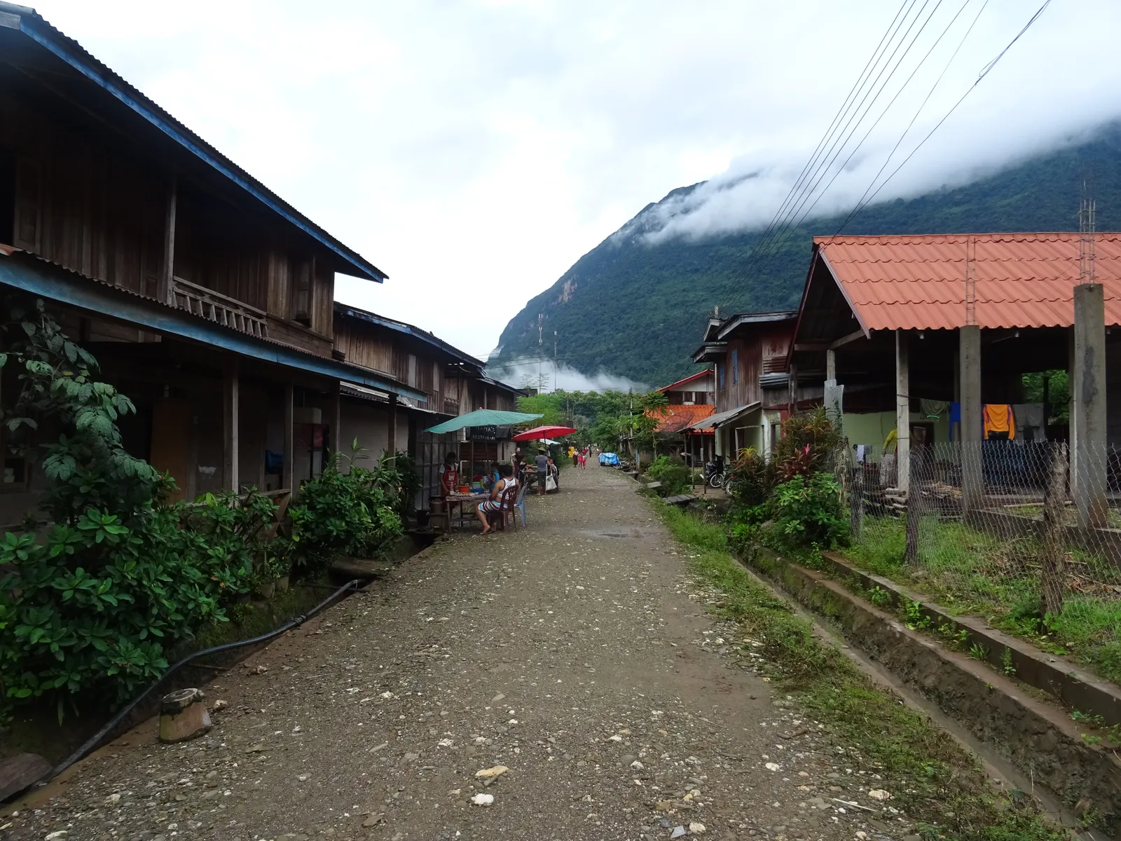 Strada principale del villaggio di Muang Ngoi Neua tra case di legno e montagne carsiche