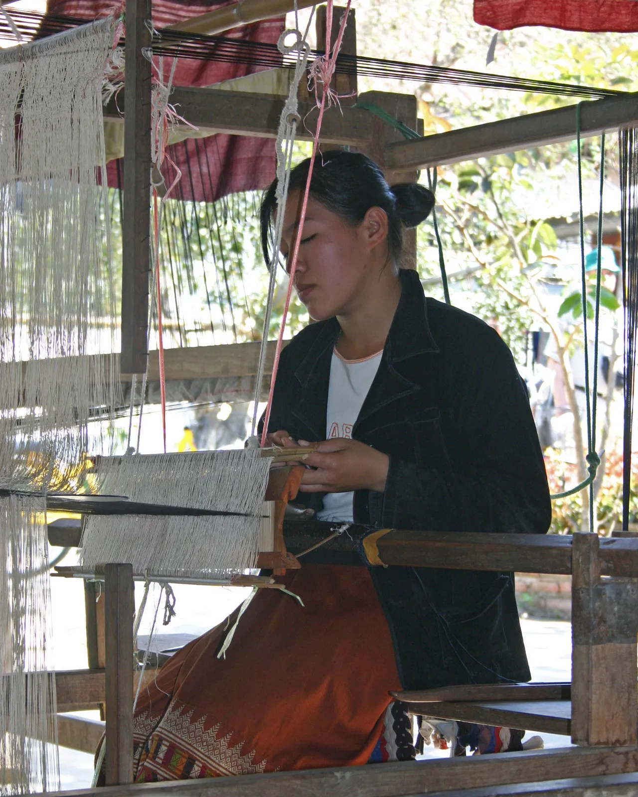 Tessitura della seta a Luang Prabang Tessitrice laotiana al lavoro sul telaio con fili di seta colorata a Luang Prabang