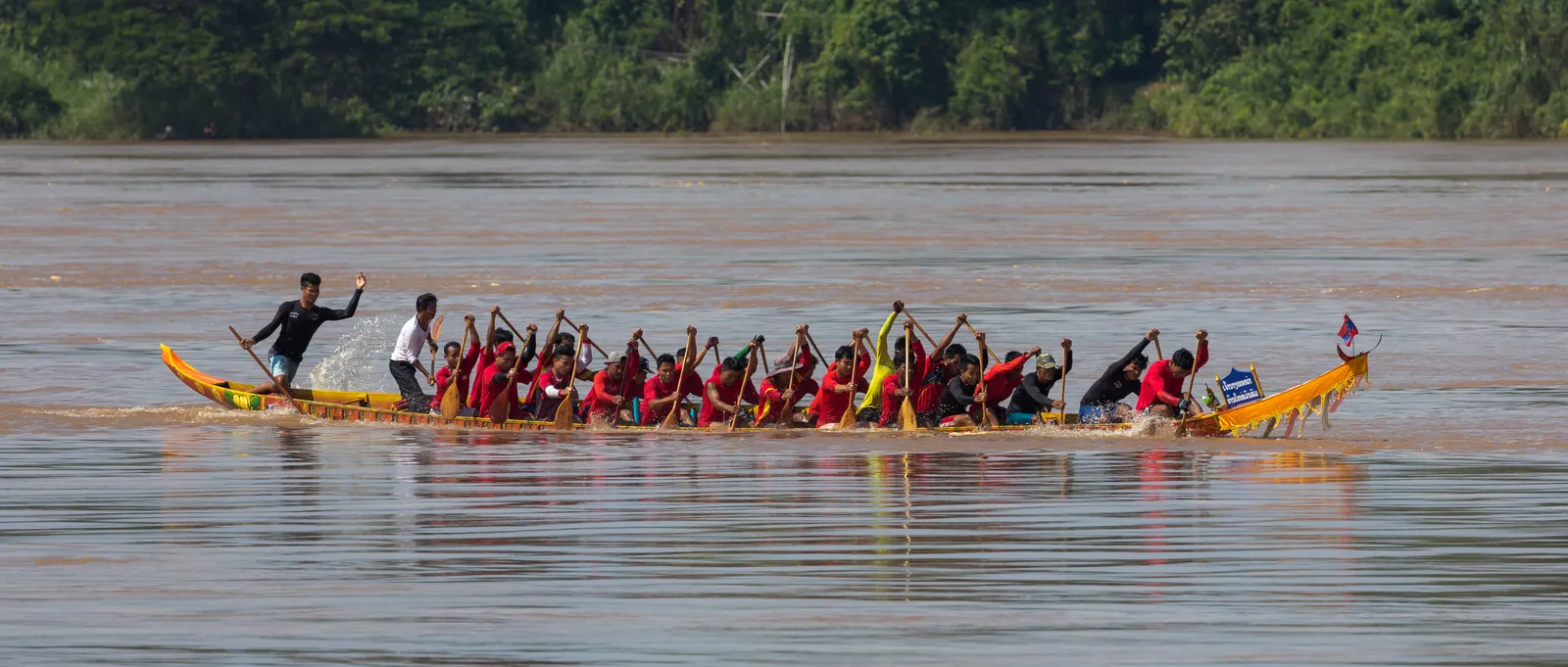 Vogatori in gara su una piroga del Mekong Vogatori in maglia rossa impegnati in una gara di piroghe nel sud del Laos, sul Mekong