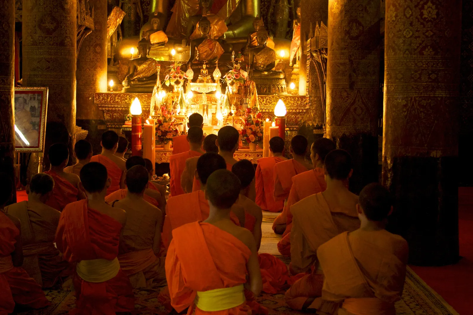 Preghiera serale al Wat Xieng Thong Preghiera serale con candele nel cortile del Wat Xieng Thong a Luang Prabang, illuminato durante il festival delle luci